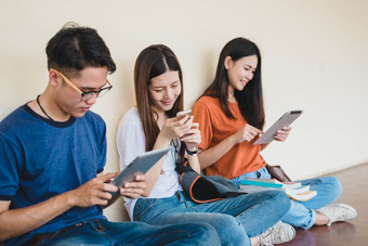 集团亚洲大学学生使用平板电脑和移动电话外教室幸福和教育学习概念回来学校概念青少年和人主题在户外和技术主题