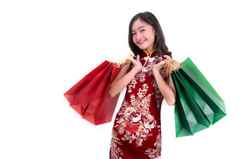 年轻的亚洲美女人穿旗袍和持有红色的和绿色购物袋手势中国人新一年节日事件孤立的白色背景假期和生活方式概念旗袍衣服