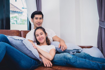 亚洲年轻的<strong>夫妻</strong>放松沙发情人和<strong>夫妻</strong>概念度蜜月和婚礼主题室内和约会主题