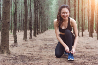 女人<strong>系</strong>鞋带当慢跑<strong>森林</strong>回来与喝水瓶旁边她的运动鞋绳子<strong>系</strong>人和生活方式概念医疗保健和健康主题公园和在户外主题