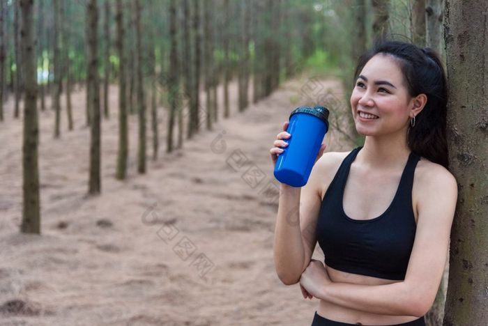 美亚洲体育运动女人休息和持有喝水瓶和放松中间森林后累了从慢跑女孩看吸引力视图锻炼概念生活方式主题