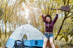 美亚洲女人持有吉他和提高手森林松森林背景人和生活方式concet野营和旅行概念
