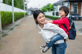 单妈妈携带和玩与她的孩子们附近首页与别墅街背景人和生活方式概念快乐家庭和首页甜蜜的首页主题在户外和自然主题