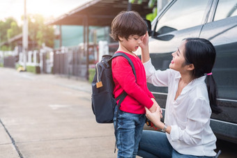 妈妈准备发送她的孩子们回来学校车早....教育和回来学校概念快乐家庭和爱的人主题