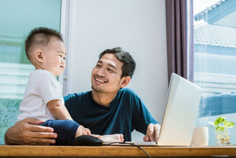 单爸爸和儿子使用移动PC在一起幸福的技术和生活方式概念快乐家庭和婴儿主题