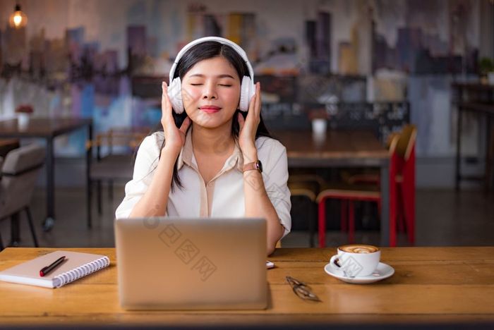 美丽的亚洲女人放松和听音乐咖啡馆与移动PC电脑和咖啡杯人和生活方式概念自由快乐工作场所主题大学和大学主题