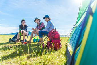 集团旅行者野营和做野餐草地与帐篷前景山和湖背景人和生活方式概念在户外活动和休闲主题背包客和徒步旅行者主题
