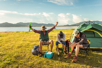 喝醉酒的游客做聚会，派对而野营和野餐草地场山和湖背景人和生活方式概念在户外活动和休闲主题背包客和徒步旅行者主题