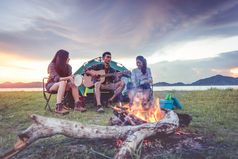 集团旅行者野营和做野餐和玩音乐在一起山和湖背景人和生活方式在户外活动和休闲主题背包客和徒步旅行者黎明和《暮光之城》