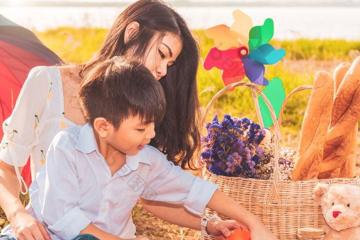 美丽的亚洲妈妈。和儿子做野餐和复活节夏天聚会，派对草地附近湖和山假期和假期人生活方式和快乐家庭生活概念泰国人