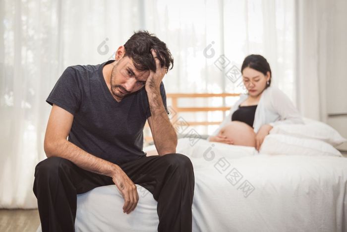 担心压力男人。坐着床上与手额头卧室严重的情绪情感与怀孕了妻子女人背景主要抑郁障碍被称为MDD概念物理医疗保健