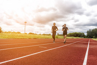 两个跑步者慢跑的比赛跟踪体育运动和社会活动概念