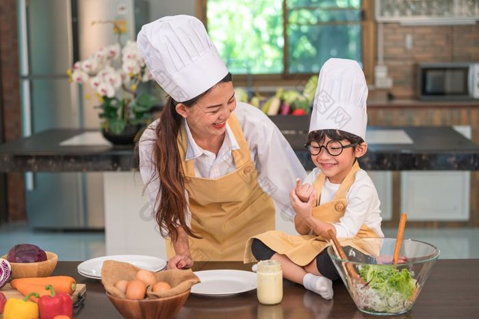 快乐美丽的亚洲女人和可爱的小男孩与眼镜准备烹饪厨房首页有趣的人生活方式和家庭自制的食物和成分概念两个泰国人生活
