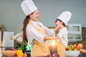 快乐美丽的亚洲女人衣服可爱的小男孩老板装为准备烹饪首页厨房人生活方式和家庭自制的食物和成分概念两个泰国人生活