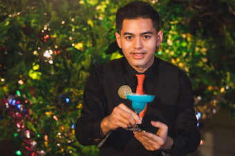 专业酒保准备新鲜的蓝色的汁鸡尾酒喝酒玻璃与冰晚上酒吧泡吧计数器占领和人生活方式概念户外和夜总会花园