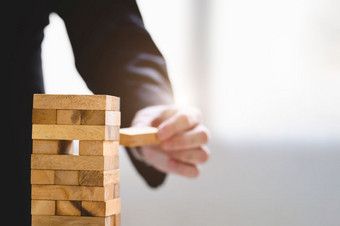 商人取和挑选一个木块堆放塔手启动项目业务组织和公司增长进步成功策略和钱投资风险管理