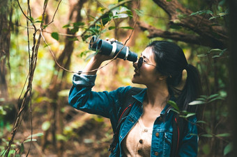 美丽的亚洲女人与双筒望远镜望远镜森林看目的地人生活方式和休闲活动自然和背包客旅行丛林背景鸟看和生活