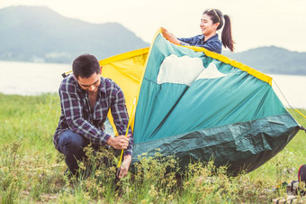 两个亚洲夫妻准备球场野营帐篷保持在户外草地在一夜之间为度蜜月野营野餐人生活方式和情人节一天爱概念自然旅行假期放松活动