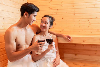 亚洲夫妻敬酒和喝酒桑拿房间为庆祝婚礼周年纪念日健康的皮肤热治疗与蒸汽桑拿概念假期和放松皮奥普克生活方式在一起