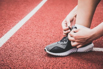 特写镜头体育运动女人系运动鞋鞋带绳子运行跟踪车道体育场体育运动中心和健身健身房概念健康的和身体构建主题运动服装和时尚主题
