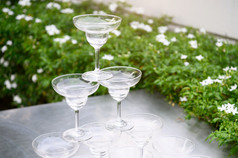 特写镜头集团叠加马提尼酒眼镜在户外计数器酒吧的花园为准备庆祝活动聚会，派对