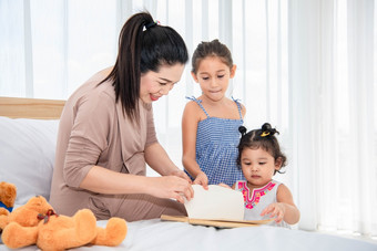 亚洲妈妈。教学混合跑女孩女儿阅读书他们的房子检疫首页概念快乐家庭主题