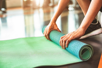关闭运动女人折叠瑜伽床<strong>垫</strong>体育运动健身健身房培训中心背景锻炼席滚动保持后瑜伽类锻炼和体育运动培训概念手<strong>地毯</strong>