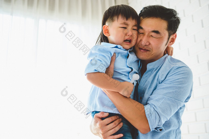 亚洲日本父亲携带和安慰他的哭儿子卧室他的首页与窗口和白色窗帘背景人生活方式健康检疫新冠病毒冠状病毒疫情