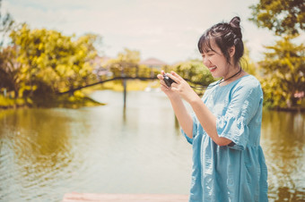 亚洲女人蓝色的<strong>衣服</strong>公共公园携带数字mirrorless相机和采取照片<strong>没有</strong>面部面具快乐情绪人生活方式和休闲概念户外旅行和自然主题