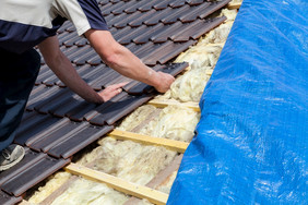 盖屋顶的人铺设瓷砖的屋顶
