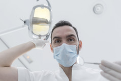 牙医靠在病人牙医rsquo椅子诊所医生与面具和工具