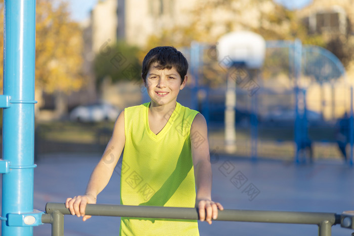 肖像年轻的青少年穿黄色的篮球无袖微笑