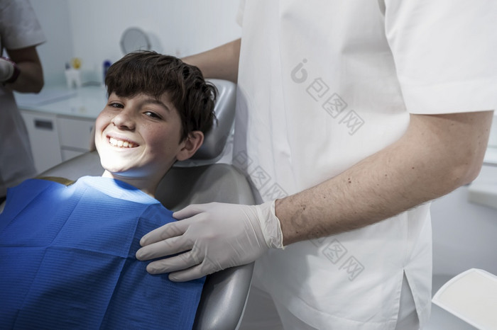 可爱的男孩被检查专业儿科牙医非常快乐男孩后的参观医生的诊所与美丽的白色微笑复制空间小男孩微笑的牙科办公室