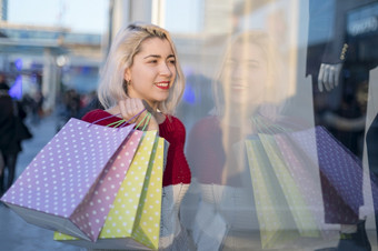 女人购物快乐女人与购物袋享受购物消费主义购物生活方式概念美丽的年轻的金发女郎女人微笑与购物袋外