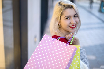 女人购物快乐女人与购物袋享受购物消费主义购物生活方式概念美丽的年轻的金发女郎女人微笑与购物袋外