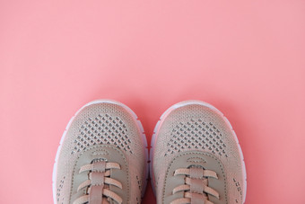 体育运动健康的生活方式概念新灰色的运动鞋柔和的粉红色的背景复制空间平躺特写镜头