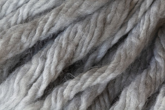 羊毛毛茸茸的线程流苏从围巾宏软灰色美利奴羊毛背景特写镜头秋天和冬天平躺斯堪的那维亚最小的风格