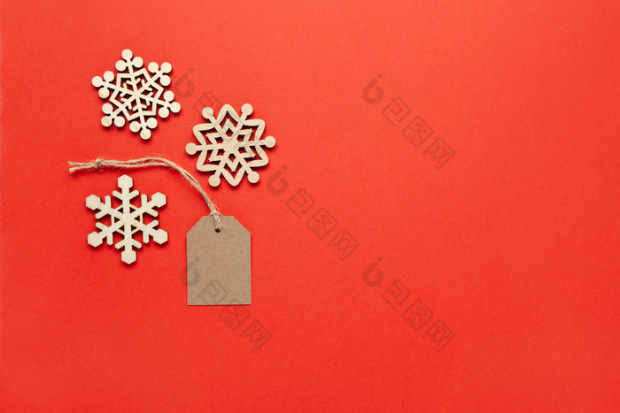 圣诞节装饰三个小木雪花和工艺标签明亮的红色的背景复制空间节日新一年销售概念水平平躺最小的风格前视图