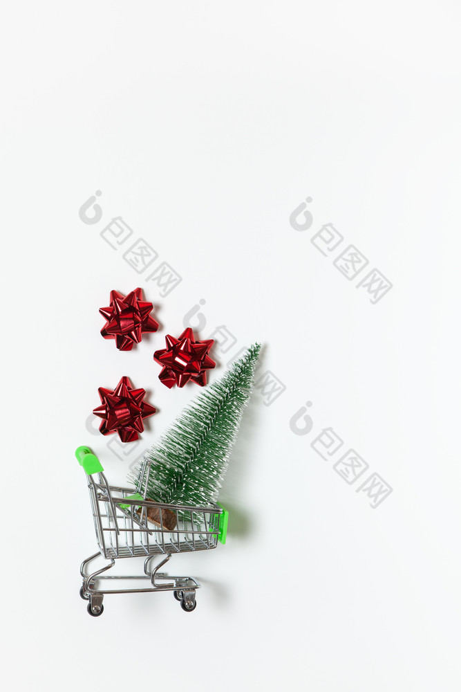圣诞节冷杉和红色的弓为礼物玩具购物车白色背景复制空间新一年销售在线购物概念垂直平躺最小的风格前视图为社会媒体