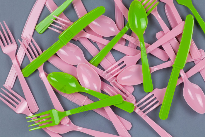 背景从可重用的可回收的粉红色的和绿色叉勺子刀使从玉米淀粉灰色纸生态零浪费替代塑料概念平躺前视图水平特写镜头