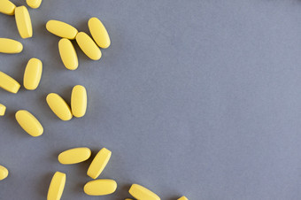 黄色的长维生素药片灰色的背景特写镜头复制空间营养补充概念健康维生素时尚的颜色照明最终灰色的水平