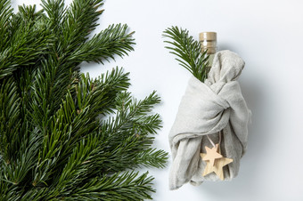 零浪费快乐圣诞节冬天礼物包装瓶日本furoshiki风格亚麻织物装饰与自然绿色分支机构冷杉诺比利斯概念环保有创意的包