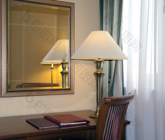酒店房间与桌子上灯和反射的镜子酒店房间与桌子上灯