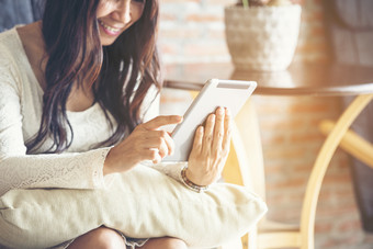 亚洲女人使用聪明的平板电脑购物在线网站智能手机与微笑脸幸福亚洲女人持有手机检查邮件从在线购物网站读博客视频博客社会媒体