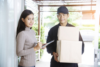 交付邮件航运包服务年轻的送货人统一的航运货物包收件人从购物在线和签署为得到了包裹包服务剪贴板