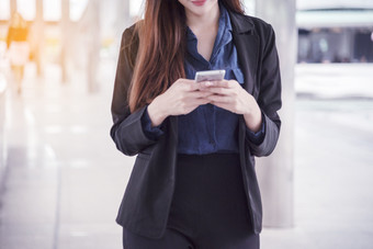 亚洲女人使用iPad购物在线网站智能手机与微笑脸幸福亚洲女人持有手机检查邮件从在线购物网站读文章博客视频博客社会媒体