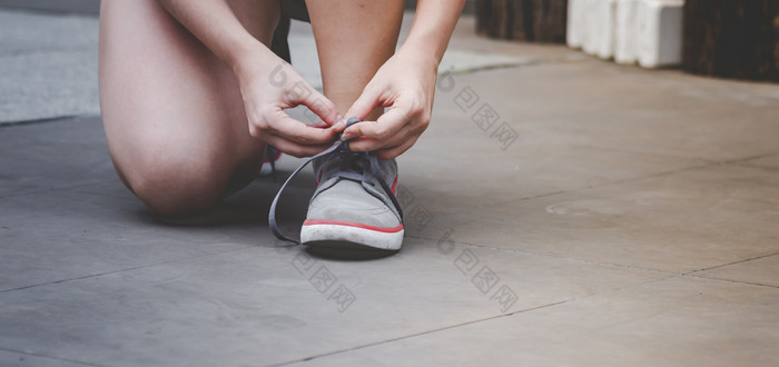 体育运动运动鞋鞋子年轻的女人跪下来鞋带准备好了运行鞋子体育运动锻炼慢跑人关闭手领带跑步者鞋带健身健身房健康的人生活方式
