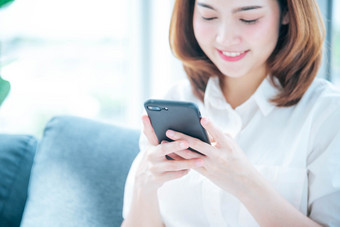 亚洲女人使用智能手机阅读在线社会媒体购物在线网站智能手机与微<strong>笑脸</strong>幸福亚洲女人持有手机检查邮件读博客<strong>视频</strong>博客社会媒体