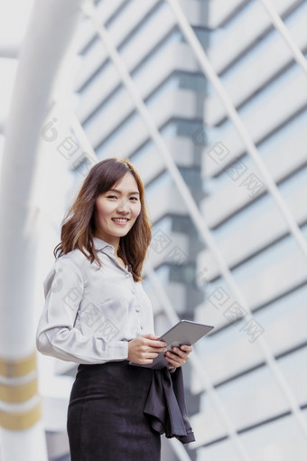 亚洲女人使用平板电脑购物在线网站智能手机与微笑脸幸福亚洲女人持有手机检查邮件从在线购物网站读文章博客视频博客社会媒体