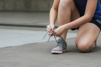 体育运动运动鞋鞋子年轻的女人跪下来鞋带准备好了运行鞋子体育运动锻炼慢跑人关闭手领带跑步者鞋带健身健身房健康的人生活方式